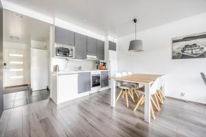 a kitchen with a wooden table and a white refrigerator at Järvenrantahuoneisto LakeVillas B1 in Ukkohalla