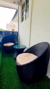 3 sillas sentadas en un balcón con césped verde en Hilltop Homes Luxury 1 Bedroom Apartment, Lekki, Lagos, Nigeria, en Lagos