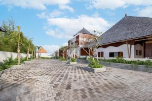 a cobblestone driveway in front of a building at La Tropica Canggu Bali By Kanaya Hospitality in Canggu