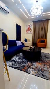 Una sala de estar con un sofá azul y una mesa. en Hilltop Homes Luxury 1 Bedroom Apartment, Lekki, Lagos, Nigeria, en Lagos