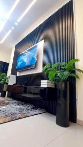 sala de estar con TV y planta en Hilltop Homes Luxury 1 Bedroom Apartment, Lekki, Lagos, Nigeria, en Lagos