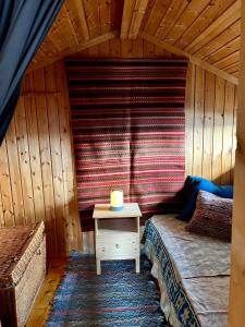 a bedroom with a bed and a table with a candle at Fiskebu at Flaksjøen in Venabygd