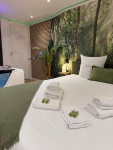 Un dormitorio con una cama blanca con toallas. en Spa et sauna - Loft Cataleya, en Belfort