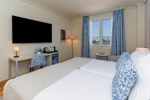 a hotel room with a bed and a television at Hesperia Córdoba in Córdoba