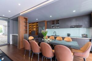 a kitchen with a table and some brown chairs at Villas VIP Trực Diện View Biển GREEN DAY 24 Sang Trọng in Vung Tau