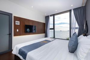 a bedroom with a large bed with a large window at Villas VIP Trực Diện View Biển GREEN DAY 24 Sang Trọng in Vung Tau +29 photos