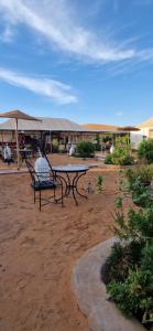 a person sitting on a bench next to a table at marvelous luxury desert stars in Merzouga