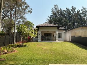 una casa blanca con una valla y un patio en Whispering Thorns Off-Site Apartment, en White River