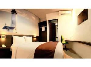 une chambre d'hôtel avec un lit et une chaise dans l'établissement Pondok Labu Residence, à Jakarta