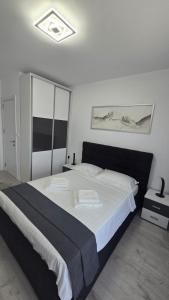 a bedroom with a large bed with white sheets at Marina Residence 2 in Constanţa