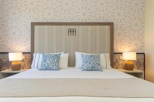 a bedroom with a large bed with blue and white pillows at Hesperia Córdoba in Córdoba