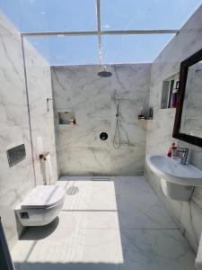 une salle de bain blanche avec toilettes et lavabo dans l'établissement City Retreat Arusha, à Arusha 33 autres photos