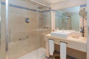 a bathroom with a glass shower and a sink at Hesperia Córdoba in Córdoba