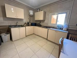 Una cocina con gabinetes blancos y una ventana. en Unique Room, en El Cairo