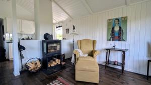 ein Wohnzimmer mit einem Stuhl und einem Kamin in der Unterkunft Soltoppen - cozy 3 bedroom cabin close to Norefjell 