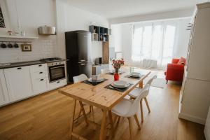 a kitchen with a wooden table and chairs in a kitchen at GuestHost - Mecenate Bright Apartment Milan in Milan +13 photos
