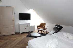 リュブリャナにあるD Roomsのベッドと壁掛けテレビのある寝室