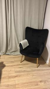 a black chair with a pillow on a wooden floor at Amphithea Luxury Apartment in Voroklini +16 photos