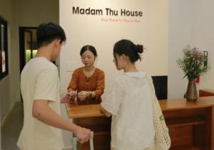 a man and two women standing in a room at Madam Thu House in Hue
