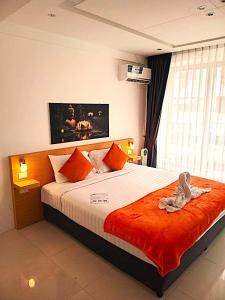a bedroom with a large bed with an orange blanket at BH Cozy Paradise Patong in Patong Beach +28 photos