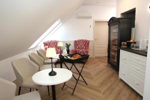 a living room with a table and chairs and a staircase at D Rooms Boutique Stay with Parking & Fast City Access in Ljubljana