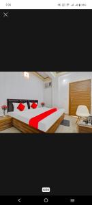 Un dormitorio con una cama grande con almohadas rojas. en Hotel Pacific view, en Dehradun