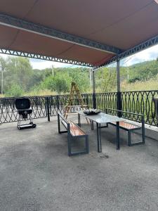 a pavilion with two benches and a table and a swing at Alvina Terrace in Tsaghkadzor