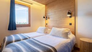 a hotel room with two beds and a window at ASAI210-2-2 Appartement 4 étoiles - Les Saisies - 11 personnes in Les Saisies