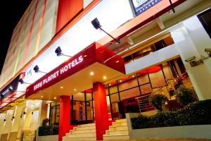 un edificio con una señal roja en la parte delantera. en Easy Planet Hat Yai, en Hat Yai