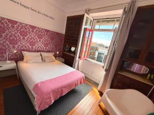a small bedroom with a bed and a window at Rivoli Cinema Hostel in Porto +24 photos