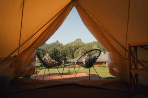 a view from inside a tent with two chairs at Glamping Natur Resort Jetřichovice in Jetřichovice