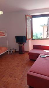 a living room with a red couch and a television at Il Fienile in Casole dʼElsa