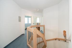 eine Holztreppe in einem Zimmer mit weißen Wänden in der Unterkunft Ferienhaus "Stella Olivia" in Lobbe + 29 Fotos