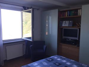 1 dormitorio con 1 cama, TV y ventana en My Holiday La Serra, en Lerici