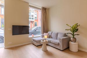 a living room with a couch and a tv at City & Trainhouse in Alkmaar