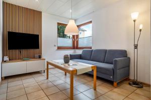 a living room with a couch and a tv at Gästehaus Heinemann - Eg3 in Langenargen