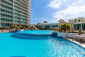 a swimming pool at a resort with blue water at Caribe 306 C in Orange Beach