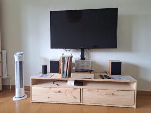 a flat screen tv on top of a wooden entertainment center at Casa Buen Camino in Arzúa