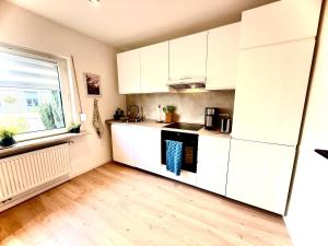 a kitchen with white cabinets and a window at Modern DesignApartment plus Garden  +11 photos