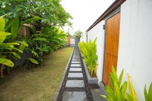 a garden with a walkway next to a building at Abimanyu Guest House in Seminyak +17 photos