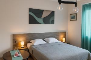 Un dormitorio con una cama con dos lámparas y una mesa. en Obilic L Apartment, en Belgrado