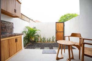 a kitchen with a table and a stool on a patio at Abimanyu Guest House in Seminyak