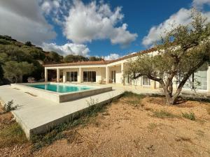 an exterior view of a house with a swimming pool at Villa Casa Bianca Sagone Piscine privée et Vue mer Familiale in Sagone