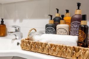 a basket filled with soap and other cleaning products on a sink at Arctic Wave City Suite in Rovaniemi +14 photos
