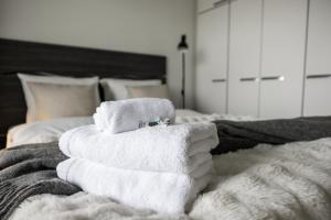 a pile of towels sitting on top of a bed at Arctic Wave City Suite in Rovaniemi