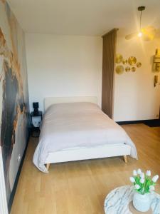 a bedroom with a white bed and a table at Charmant Studio in Vitré