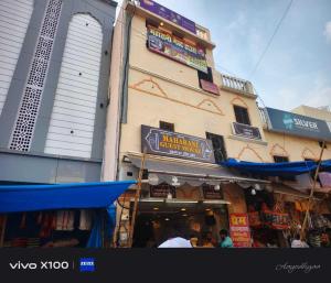 un edificio con cartelli accanto a un negozio di SPOT ON Maharani guest house a Ayodhya Altre 21 foto