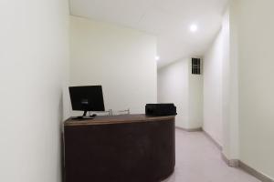 una camera con scrivania e monitor per computer; di SPOT ON Maharani guest house a Ayodhya