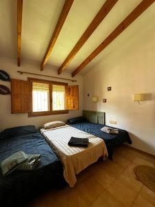 two beds in a large room with wooden ceilings at Casa cerca del mar muy tranquila, Alicante El Campello in El Campello