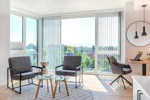 a living room with two chairs and a table at Stadtloft Penthouse "Eversten" Neubau Business Apartments für Projekt- und Firmenaufenthalte in Oldenburg